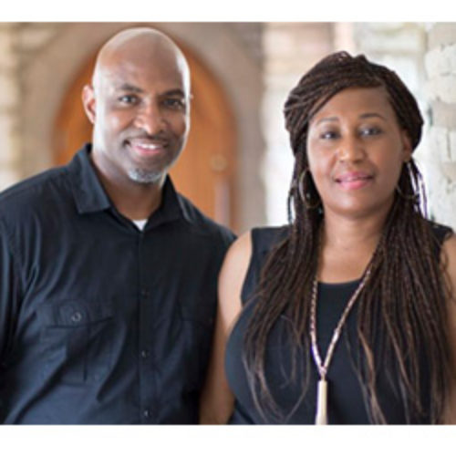 Black couple wearing black and smiling at camera